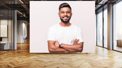 Indian young man standing with hands folded against white background Wall mural